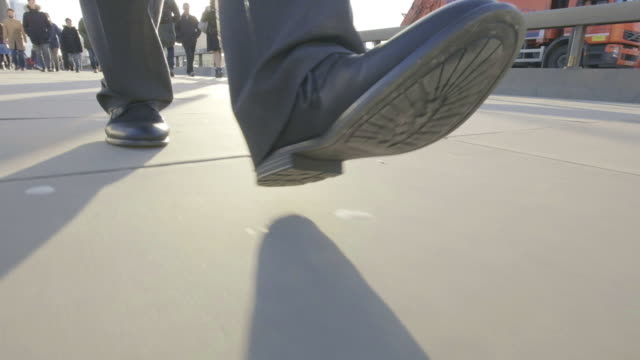 Low-angle-view-of-a-business-man's-feet-walking
