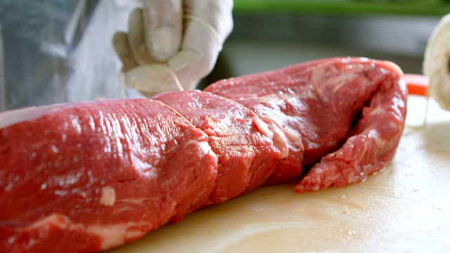 Carnicero-carne-con-hilo-de-atar-en-tienda-4k