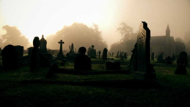 Viejo-cementerio-espeluznante-con-la-niebla-de-la-mañana-y-de-la-iglesia-en-la-distancia