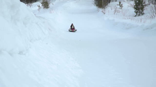 Woman-and-Girl-Riding-Fast-on-a-Snow-Tubing