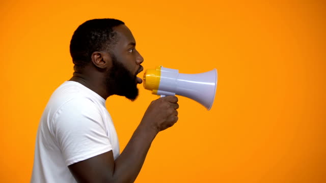 African-American-man-using-megaphone-for-protest,-calling-to-action,-side-view