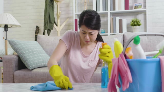 mujer-que-llevaba-guantes-protectores-limpiando-la-mesa