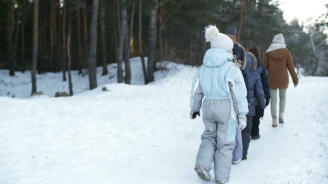 Gran-familia-caminando-en-el-bosque-cubierto-de-nieve