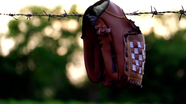 Bewegen-Sie-den-Blick-auf-einen-Baseballhandschuh-mit-dem-Zaun-der-Feldpraxis