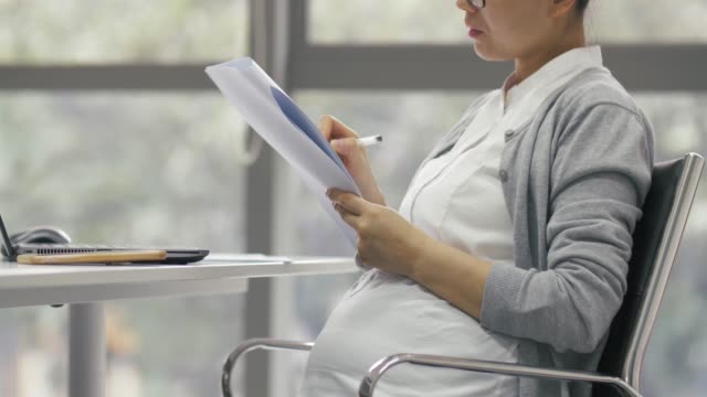 Seitenansicht-der-schwangschwangeren-Geschäftsfrau-der-Chinesin,-die-im-Büro-arbeitet