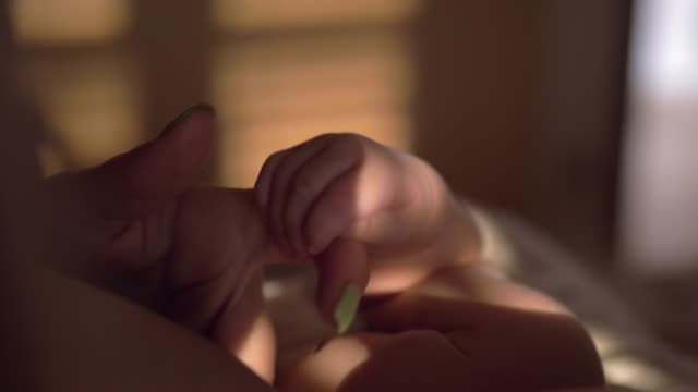 Bebé-jugando-con-el-dedo-de-la-madre-al-amamantar