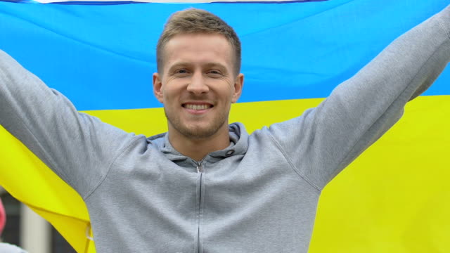 Männliche-Aktivistin,-die-ukrainische-Flagge-hisst-und-patriotischen-Slogan,-Unabhängigkeitstag