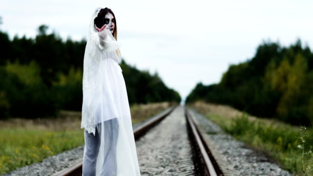 The-young-woman-with-make-up-of-dead-bride-for-Halloween-on-the-railway-track.-4K