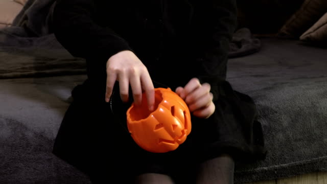 Kleines-Mädchen-mit-Halloween-Kürbis-Kopf-behälter-für-Süßigkeiten