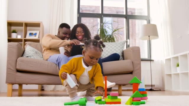 afrikanische-Baby-Mädchen-spielen-mit-Spielzeug-Blöcke-zu-Hause