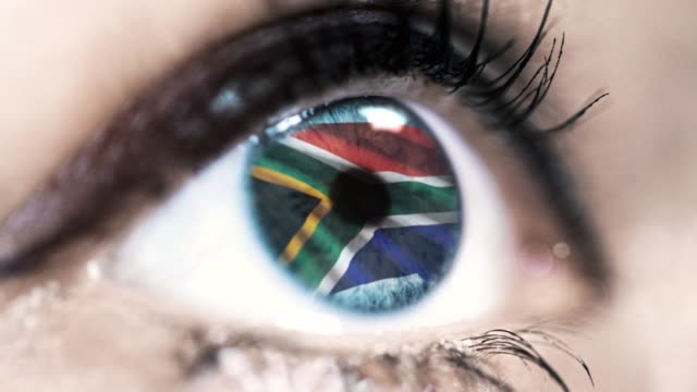 Frau-blaues-Auge-in-Nahaufnahme-mit-der-Flagge-von-Südafrika-in-Iris-mit-Windbewegung.-Videokonzept
