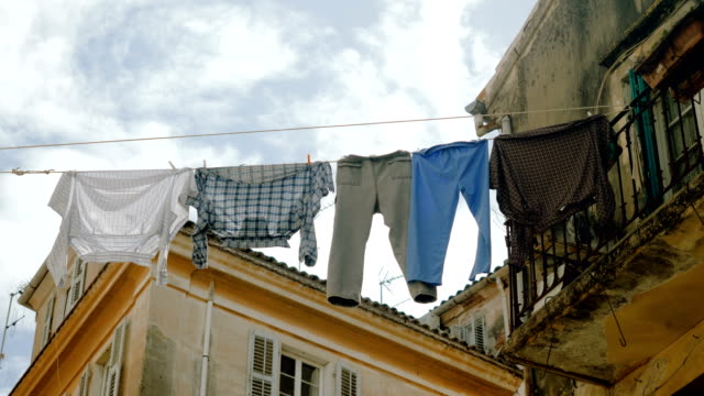 Saubere-Kleidung-und-Bettwäsche,-die-an-einer-Wäscheleine-hängt,-um-im-Freien-in-den-Straßen-zu-trocknen.-4K