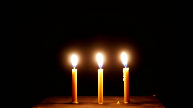 time-lapse,Close-up-candle-is-burning-on-black-background.