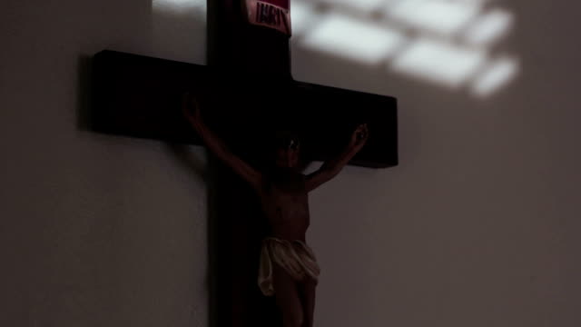 Kruzifix-an-der-Wand-des-Jesus-am-Kreuz-als-Sonnenlicht-bewegt-sich-tagsüber