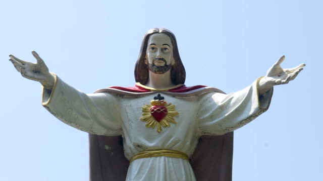 View-of-Jesus-Christ-with-open-arms-shifting-to-cloudless-sky,-vertical-panorama