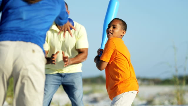 Familia-afroamericana-jugando-al-béisbol-en-vacaciones-en-la-playa