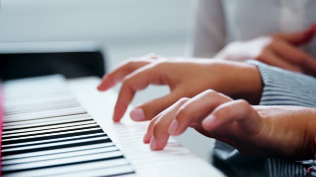 Nahaufnahme-der-Schüler-mit-Lehrer-Klavier-Musikunterricht