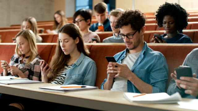 Multi-Ethnic-Group-of-Students-Using-Smartphones-During-the-Lecture.-Young-People-Using-Social-Media-while-Studying-in-the-University.