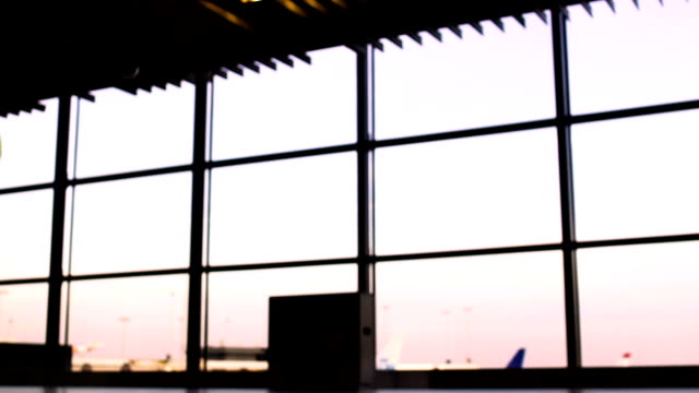 Silhouettes-of-business-people-walking-in-airport,-plane-takeoff-on-background