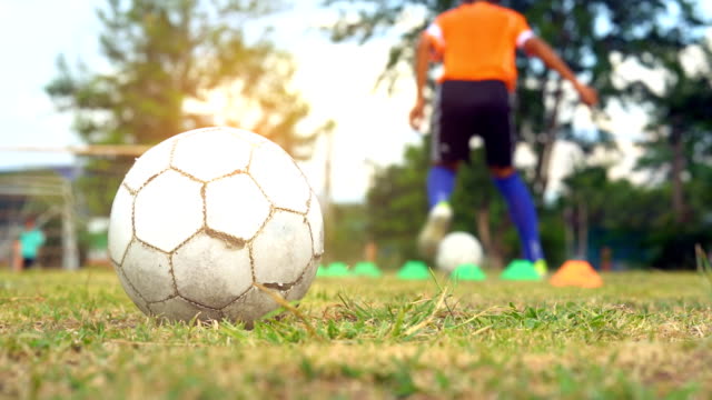 Fußball-ball-auf-Feld-auf-unscharfen-Fußball-spielen-sportliche-und-Trainingssteuerung-ball-und-schießen-Ziel-auf-Feld-im-Sonnenuntergang