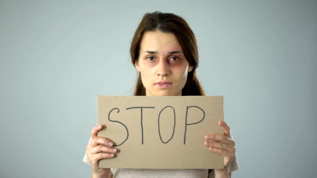 Geknickte-Frau-mit-Stop-Schild,-Hilferuf,-Hilfe-für-Opfer-von-Gewalt