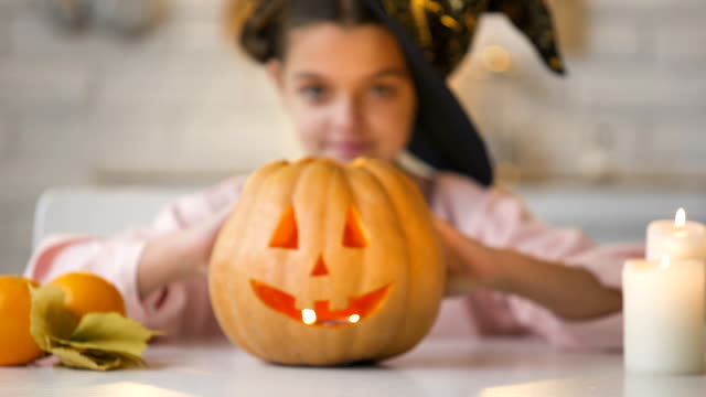 Kleine-Hexe-zeigen-unheimlich-Jack-o-Lantern-Kürbis,-Halloween-Party-vorbereiten