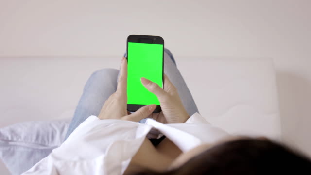 Frau-nutzt-Smartphone-auf-Bett