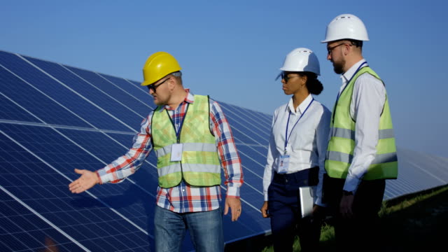 Elektrischen-Arbeiter-zu-Fuß-an-einem-Solarpark