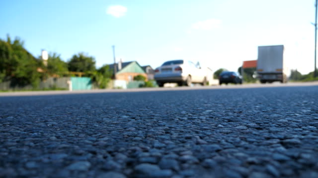 Blurred-cars-go-one-by-one-on-the-road.-Vehicles-drive-along-asphalt-road.-Traffic-in-highway.-Low-angle-view-Slow-motion