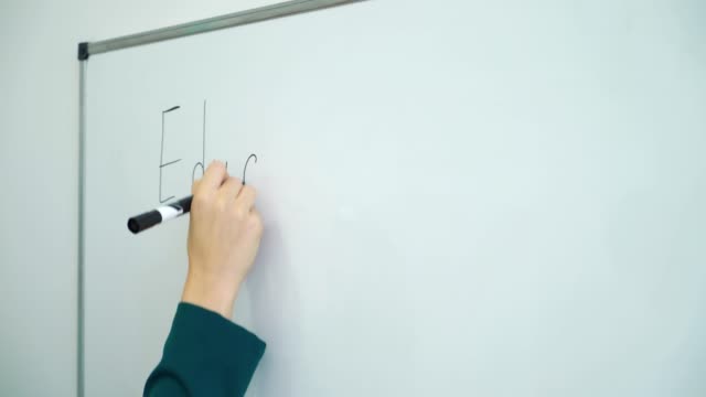 Closeup-Lehrerin-Handschrift-auf-einem-Whiteboard-im-Klassenzimmer