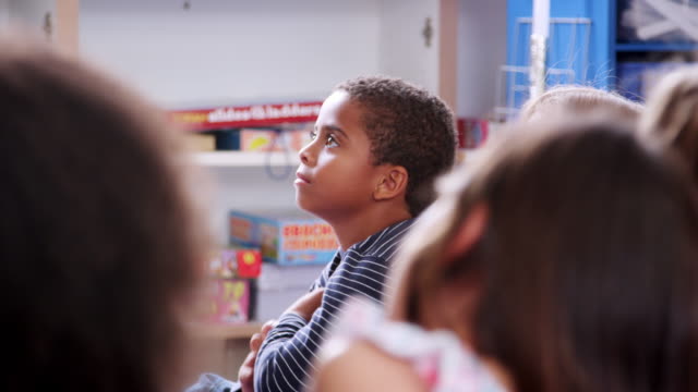 Niños-en-edad-escolar-primaria-y-escuchando-un-cuento-en-clase