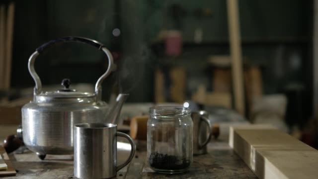 Stahl-Teekanne,-Edelstahl-Tassen-und-eine-Dose-Teeblätter