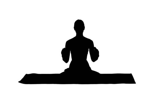 Silhouette-schöne-junge-Frau-sitzt-im-Yoga-pose-Lotus-ändern-der-Position-der-Hände