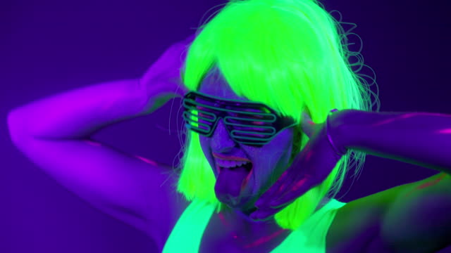 Slow-motin-of-beautiful-sexy-women-with-fluorescent-make-up-and-clothing-dancing-in-neon-light.-Night-club,-Party-Concept.