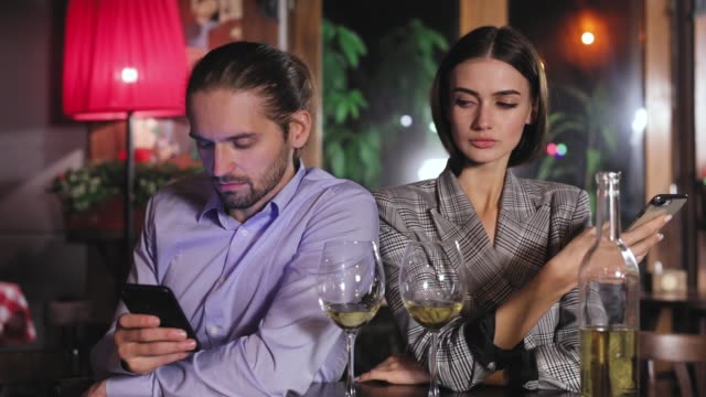 Communication-Problem.-People-Using-Phone-On-Date-At-Restaurant