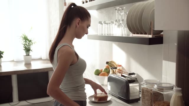 Frau,-die-Toasts-auf-Frühstück-modernen-leichten-Küche-kochen