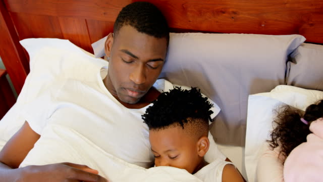 Vorderansicht-des-schwarzen-Familie-schlafen-im-Schlafzimmer-zu-Hause-4k