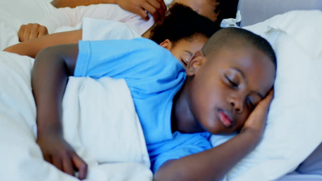 Vorderansicht-des-jungen-schwarzen-Familie-schlafen-zusammen-im-Bett-im-Schlafzimmer-bequem-nach-Hause-4-k