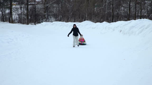 Woman-Pulling-a-Snow-Tube-with-Little-Girl