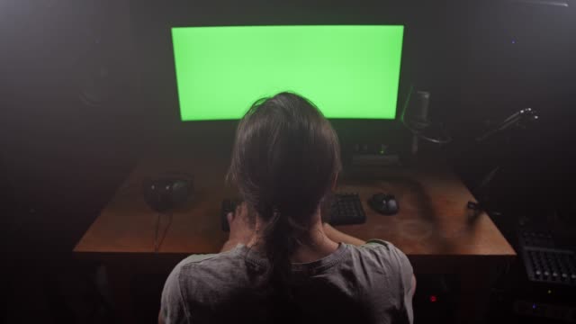 Kreativer-Mann,-der-vor-dem-Computer-arbeitet.-Vor-ihm-liegt-ein-grüner-Bildschirm.-4K-Slow-Mo