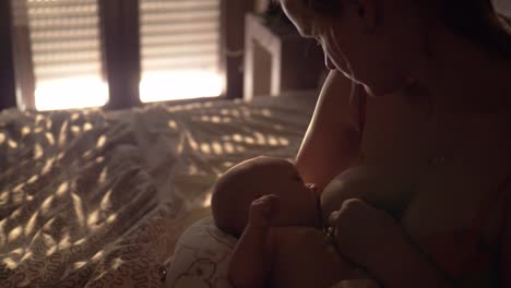 Mother-breastfeeding-baby-in-bedroom