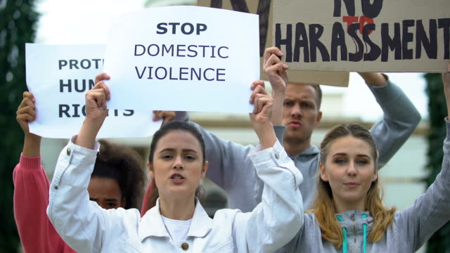 Menge-skandiert-Parolen-auf-häuslicher-Gewalt-Kundgebung-winken-Banner-für-Menschenrecht