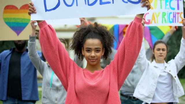 Frau-hält-Liebe-ohne-Grenzen-Plakat-zusammen-mit-LGBT-Aktivisten,-Stolz