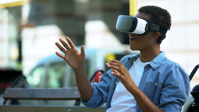Mixed-Race-Teen-Junge-sitzt-auf-der-Bank-in-Virtual-Reality-Headset,-modernes-Gerät