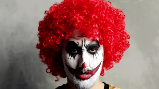 Porträt-von-beängstigend-wütend-Enman-Clown-mit-Halloween-Make-up-und-rote-lockige-Perücke