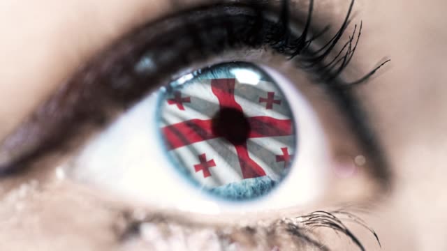 woman-blue-eye-in-close-up-with-the-flag-of-Georgia-in-iris-with-wind-motion.-video-concept
