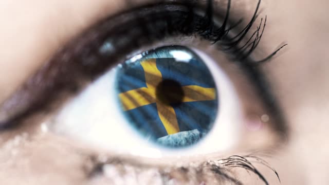 Frau-blaues-Auge-in-Nahaufnahme-mit-der-Flagge-von-Schweden-in-Iris-mit-Windbewegung.-Videokonzept