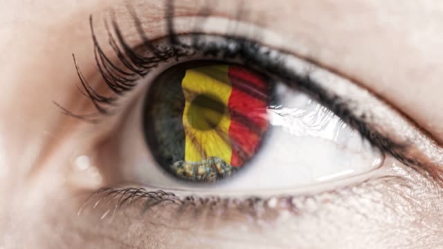 woman-green-eye-in-close-up-with-the-flag-of-belgium-in-iris-with-wind-motion.-video-concept