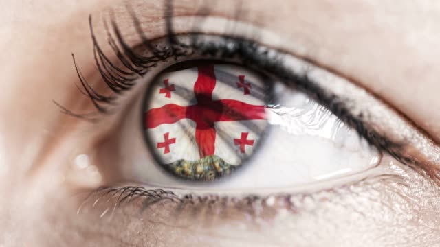 woman-green-eye-in-close-up-with-the-flag-of-Georgia-in-iris-with-wind-motion.-video-concept