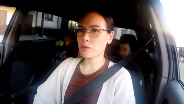 Schöne-Mutter-mit-drei-Kindern-fahren-Auto